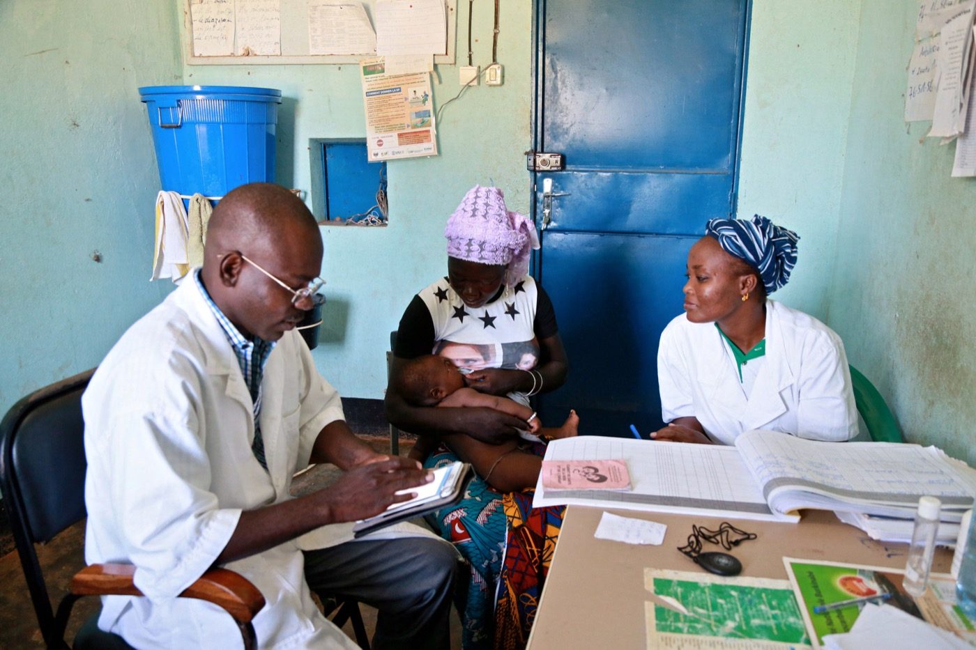 A health worker in Burkina Faso examining a child with a caregiver