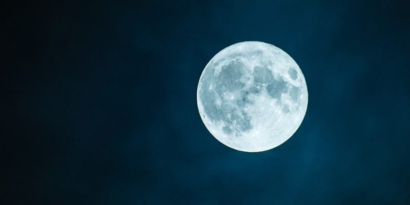 A full moon glowing in a dark night sky
