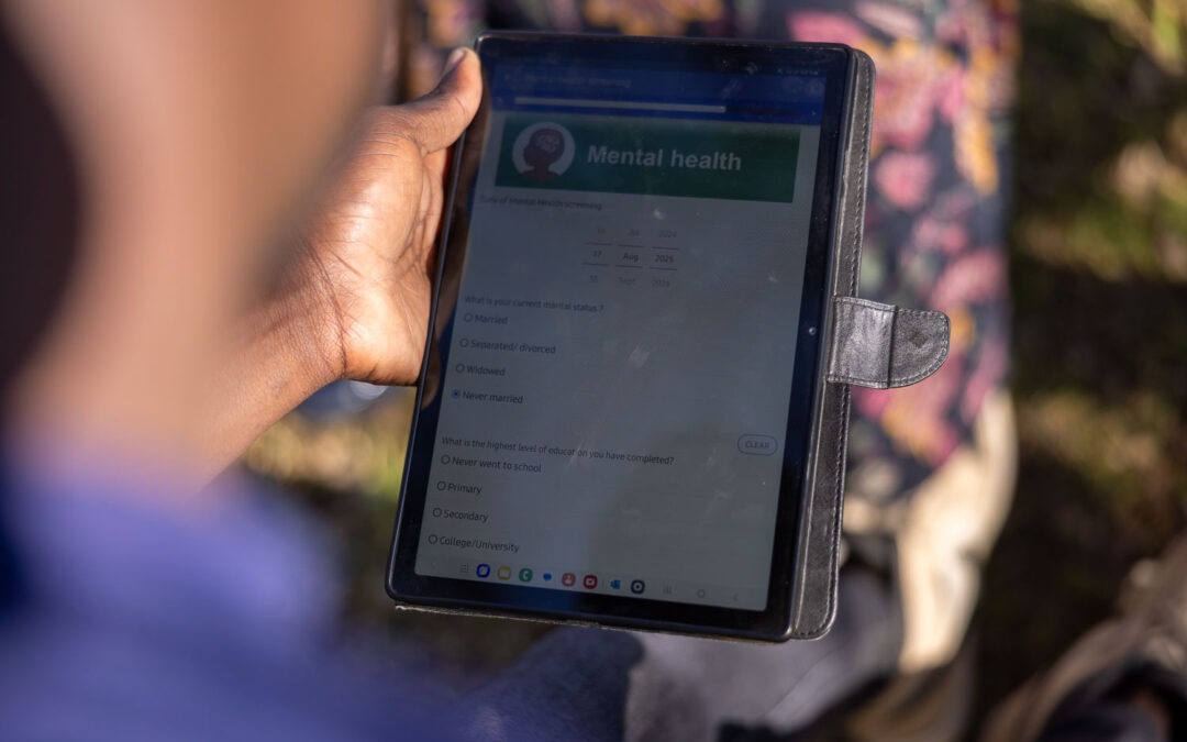 An over-the-shoulder view of a person holding a tablet, which displays a digital form titled "Mental health" with survey questions.