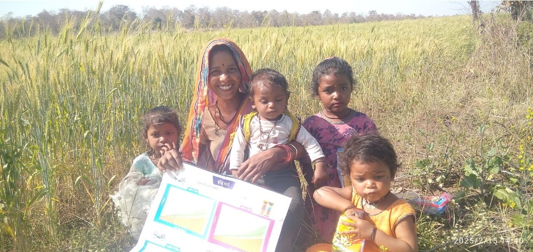 A smiling mother and children in rural India holding a nutrition and growth monitoring chart, representing predictive analytics in public health.